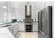 Modern kitchen with white cabinets, stainless steel appliances, and a mosaic backsplash at 108 Corte Del Rosa, Venice, FL 34285