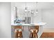 Kitchen with breakfast bar, white cabinets, and wicker barstools at 108 Corte Del Rosa, Venice, FL 34285