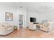 Bright living room with comfy seating and a view into a bedroom at 108 Corte Del Rosa, Venice, FL 34285