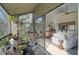 Screened-in balcony with plants and view of living room with white furniture, light wood floors, and brown dining table and chairs at 109 Woodland Pl, Osprey, FL 34229