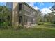 Exterior view of two-story condo with screened balconies and green lawn at 109 Woodland Pl, Osprey, FL 34229