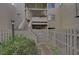 Private entrance to a condo with stairs leading to the second floor and lush landscaping at 109 Woodland Pl, Osprey, FL 34229