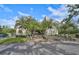 Front exterior view of a two-story condo with palm trees and a driveway at 109 Woodland Pl, Osprey, FL 34229
