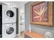 Laundry area with stacked washer and dryer, conveniently located near the bathroom at 109 Woodland Pl, Osprey, FL 34229
