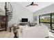 Living room with white couch, wood floors, spiral staircase, and access to the balcony at 109 Woodland Pl, Osprey, FL 34229