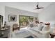 Bright living room with vaulted ceiling, wood floors, and sliding glass door to the balcony at 109 Woodland Pl, Osprey, FL 34229