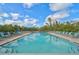 Inviting community pool with lounge chairs, umbrellas, and lush landscaping at 109 Woodland Pl, Osprey, FL 34229