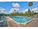 Community pool with ample lounge chairs, umbrellas, and a view of trees at 109 Woodland Pl, Osprey, FL 34229
