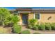 The home's entrance, featuring a dark-colored door, framed by lush green shrubs and palm trees at 12667 Sorrento Way, Bradenton, FL 34211