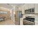 Bright kitchen featuring stainless steel appliances, white cabinetry, and an adjacent dining area at 12667 Sorrento Way, Bradenton, FL 34211
