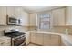 Kitchen with stainless steel appliances, white cabinets, and light countertops at 12667 Sorrento Way, Bradenton, FL 34211