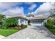 Beautiful home with a light blue exterior, landscaped yard, and paver driveway at 15407 Castle Park Ter, Lakewood Ranch, FL 34202