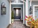 Inviting front entrance with a navy blue door, flanked by elegant lanterns and potted plants at 15407 Castle Park Ter, Lakewood Ranch, FL 34202