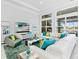 Open living space with white sectional sofa, large windows, and teal accents at 15407 Castle Park Ter, Lakewood Ranch, FL 34202