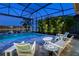 Pool and patio furniture with lake view at night at 15407 Castle Park Ter, Lakewood Ranch, FL 34202