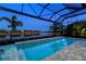 Stunning view of a pool and lake at dusk with a covered patio at 15407 Castle Park Ter, Lakewood Ranch, FL 34202
