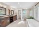 Modern bathroom featuring dual vanities, a walk-in shower, and a soaking tub at 1656 Hillview St, Sarasota, FL 34239
