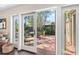 Sliding glass doors open to a brick patio with seating and lush greenery at 1656 Hillview St, Sarasota, FL 34239