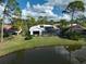 Backyard oasis with pool and lake view; solar panels at 2077 Apalachee Ln, Nokomis, FL 34275