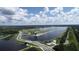 Expansive aerial view of a lake, a bridge, and a modern building amidst a green, scenic landscape at 2960 Sandringham Pl, Sarasota, FL 34235