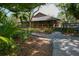 Charming clubhouse with inviting outdoor seating surrounded by lush tropical foliage and beautiful landscaping at 2960 Sandringham Pl, Sarasota, FL 34235