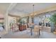 Elegant dining room with a glass-top table, chandelier, and mirrored wall at 2960 Sandringham Pl, Sarasota, FL 34235