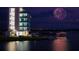 Nighttime view of a modern building and waterfront area, illuminated by fireworks at 2960 Sandringham Pl, Sarasota, FL 34235