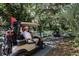 Golf carts on a path surrounded by lush greenery and mature trees at 2960 Sandringham Pl, Sarasota, FL 34235