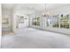 Open-concept living room featuring a large mirror wall, chandelier, and bright windows at 2960 Sandringham Pl, Sarasota, FL 34235