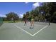 Outdoor pickleball courts surrounded by lush greenery provide a recreational space for active residents at 2960 Sandringham Pl, Sarasota, FL 34235