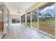 Spacious sunroom featuring tile flooring, ceiling fan and slider windows with backyard views at 2960 Sandringham Pl, Sarasota, FL 34235