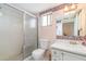 Bathroom featuring a walk-in shower, a toilet, a single sink vanity and decorative wallpaper at 3937 Lake Bayshore Dr # 401, Bradenton, FL 34205