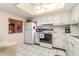 Kitchen featuring white cabinetry, updated appliances and a window connecting it to dining area at 3937 Lake Bayshore Dr # 401, Bradenton, FL 34205