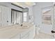 Bathroom with white vanity, toilet, shower and patterned curtain at 4875 Wood Pointe Way, Sarasota, FL 34233