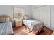 Bedroom with two twin beds, closet, wood-look flooring, and natural light at 4875 Wood Pointe Way, Sarasota, FL 34233