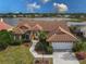 Attractive single-story home with tile roof, landscaped yard, and waterfront view at 4875 Wood Pointe Way, Sarasota, FL 34233