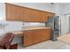 Kitchen with stainless steel appliances, wood cabinetry, and a built-in desk area at 4875 Wood Pointe Way, Sarasota, FL 34233
