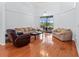 Spacious living room with wood floors, a view of the screened pool, and comfortable seating at 4875 Wood Pointe Way, Sarasota, FL 34233
