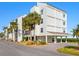 Modern condo building with water views and palm trees at 4900 Gulf Of Mexico Dr # 205, Longboat Key, FL 34228