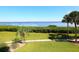 Serene waterfront view with palm trees and lush greenery at 4900 Gulf Of Mexico Dr # 205, Longboat Key, FL 34228