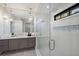 Elegant bathroom featuring a glass shower, gray vanity, and hexagon floor tiles at 518 Blue Heron Dr, Anna Maria, FL 34216