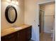 Bathroom vanity features granite countertop, dark wood cabinets, an oval mirror, and a shower with glass door at 5405 Fair Oaks St # 5405, Bradenton, FL 34203
