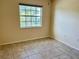 A small bedroom is brightened with natural light from a large window with tile floor at 5405 Fair Oaks St # 5405, Bradenton, FL 34203
