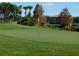 Scenic view of a lush green golf course with a flag, and a building in the background at 5405 Fair Oaks St # 5405, Bradenton, FL 34203