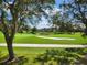 Picturesque view of the lush golf course and pond, framed by mature trees and distant residential buildings at 5405 Fair Oaks St # 5405, Bradenton, FL 34203