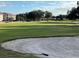 Scenic view of the lush green golf course with sand trap and mature trees and condominium homes in the background at 5405 Fair Oaks St # 5405, Bradenton, FL 34203