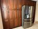 Modern stainless steel refrigerator nestled between elegant wooden cabinets, offering ample storage space in the kitchen at 5405 Fair Oaks St # 5405, Bradenton, FL 34203