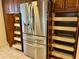 Stainless steel refrigerator with surrounding wooden cabinets, including pull-out shelving, maximizing kitchen storage at 5405 Fair Oaks St # 5405, Bradenton, FL 34203