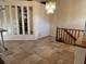 Open living area with staircase, tile flooring, and decorative chandelier at 5405 Fair Oaks St # 5405, Bradenton, FL 34203