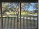 View from enclosed lanai overlooking lush green golf course and mature trees at 5405 Fair Oaks St # 5405, Bradenton, FL 34203